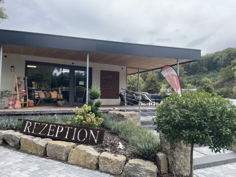 Rezeption des Camping Resort Limburg mit überdachtem Eingangsbereich und bepflanztem Vorplatz