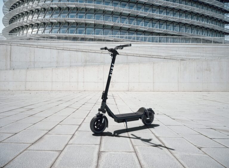Pure Air6 E-Scooter vor moderner Architektur als breites Titelmotiv