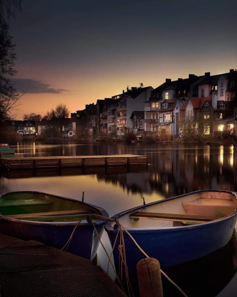 Abendstimmung am Ufercafé Gischler mit Ruderbooten und beleuchteter Marburger Altstadt