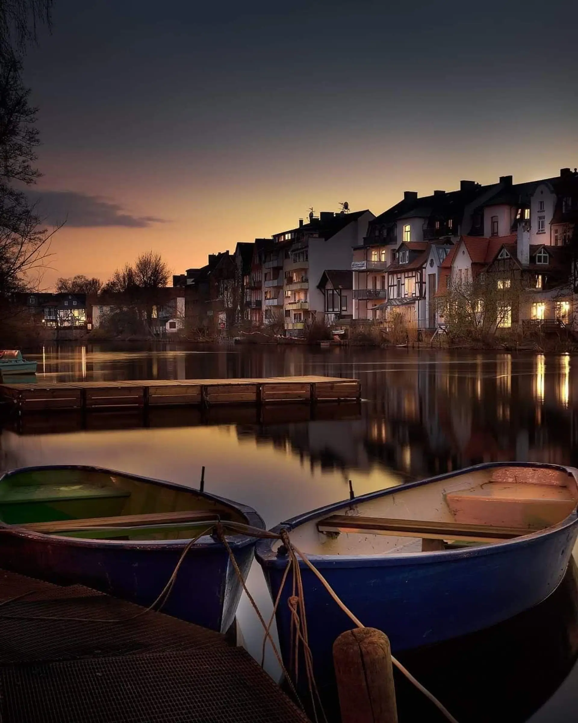 Abendstimmung am Ufercafé Gischler mit Ruderbooten und beleuchteter Marburger Altstadt